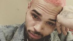 El rapero Chris Brown con el pelo te&ntilde;ido de color rosa y el rostro serio