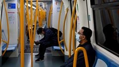 Dos pasajeros viajan protegidos con mascarillas y guardando el distanciamiento social en un vag&oacute;n del Metro de Madrid.