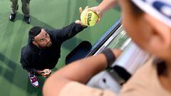El tenista australiano Nick Kyrgios firma una pelota a un aficionado tras anunciar su retirada en el cuadro individual del Open de Atlanta.