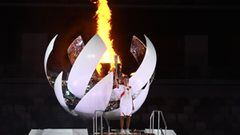 Japanese Tennis player Naomi Osaka lights the Olympic flame in the cauldron during the opening ceremony of the Tokyo 2020 Olympic Games at the Olympic Stadium. 