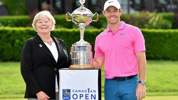 La presidenta de Golf Canadá Liz Hoffman y el golfista norirlandés Rory McIlroy posan con el trofeo de campeón del Canadian Open.