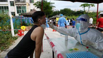 A medical worker takes a swab sample from a resident for the nucleic acid test at a makeshift testing site, amid lockdown measures to curb the coronavirus disease (COVID-19) outbreak in Sanya, Hainan province, China August 9, 2022. China Daily via REUTERS ATTENTION EDITORS - THIS IMAGE WAS PROVIDED BY A THIRD PARTY. CHINA OUT.