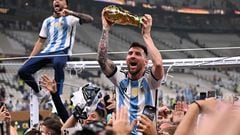 Argentina's forward #10 Lionel Messi lifts the FIFA World Cup Trophy as he celebrateswith supporters winning the Qatar 2022 World Cup final football match between Argentina and France at Lusail Stadium in Lusail, north of Doha on December 18, 2022. (Photo by Kirill KUDRYAVTSEV / AFP)