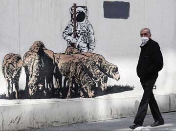 Istanbul (Turkey), 27/04/2020.- A man wearing face mask passes by a graffiti in Istanbul, Turkey, 27 April 2020. Turkish President Recep Tayip Erdogan announced that there will be curfew in 31 big cities
