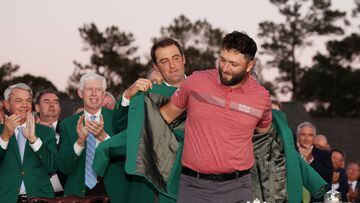 El golfista español Jon Rahm recibe de manos de Scottie Scheffler la Chaqueta Verde como campeón del Masters de Augusta 2023.