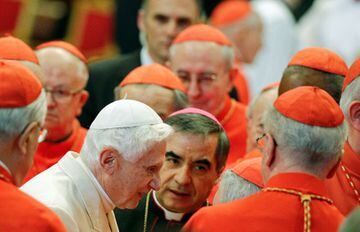 Pope Emeritus Benedict XVI is greeted by Cardinals as he arrives in Saint Peter's Basilica at the Vatican, 2014.