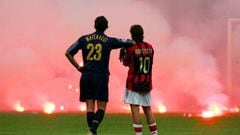 Inter Milan's Marco Materazzi (L) and AC Milan's Manuel Rui Costa waits on the pitch as supporters throw flares onto the pitch during their Champions League quarter-final second leg soccer match at the San Siro Stadium in Milan April 12, 2005.