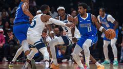 Dallas Mavericks' guard Kyrie Irving #11 is guarded by Minnesota Timberwolves' guard Mike Conley #10