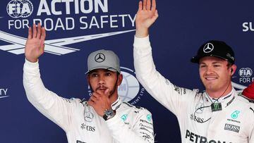 Mercedes AMG Petronas F1 Team&#039;s German driver Nico Rosberg (R) celebrates taking pole position next to his teammate Mercedes AMG Petronas F1 Team&#039;s British driver Lewis Hamilton (L) after the qualifing session at the Formula One Japanese Grand P