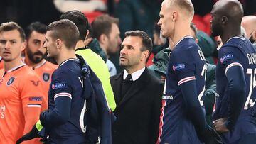 Istanbul Basaksehir&#039;s Turkish coach Okan Buruk (C) looks on as he leaves the pitch after the game was suspended amid allegations of racism by one of the match officials during the UEFA Champions League group H football match between Paris Saint-Germa