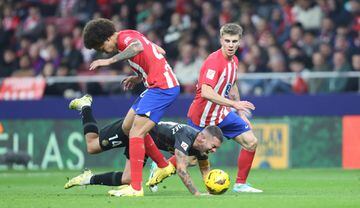 Dani Rodríguez cae al césped entre los jugadores rojiblancos, Axel Witsel y Pablo Barrios.
