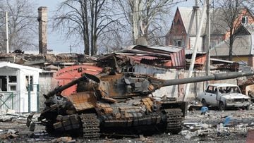 A woman walks past a destroyed tank in a street damaged during Ukraine-Russia conflict in the separatist-controlled town of Volnovakha in the Donetsk region, Ukraine.