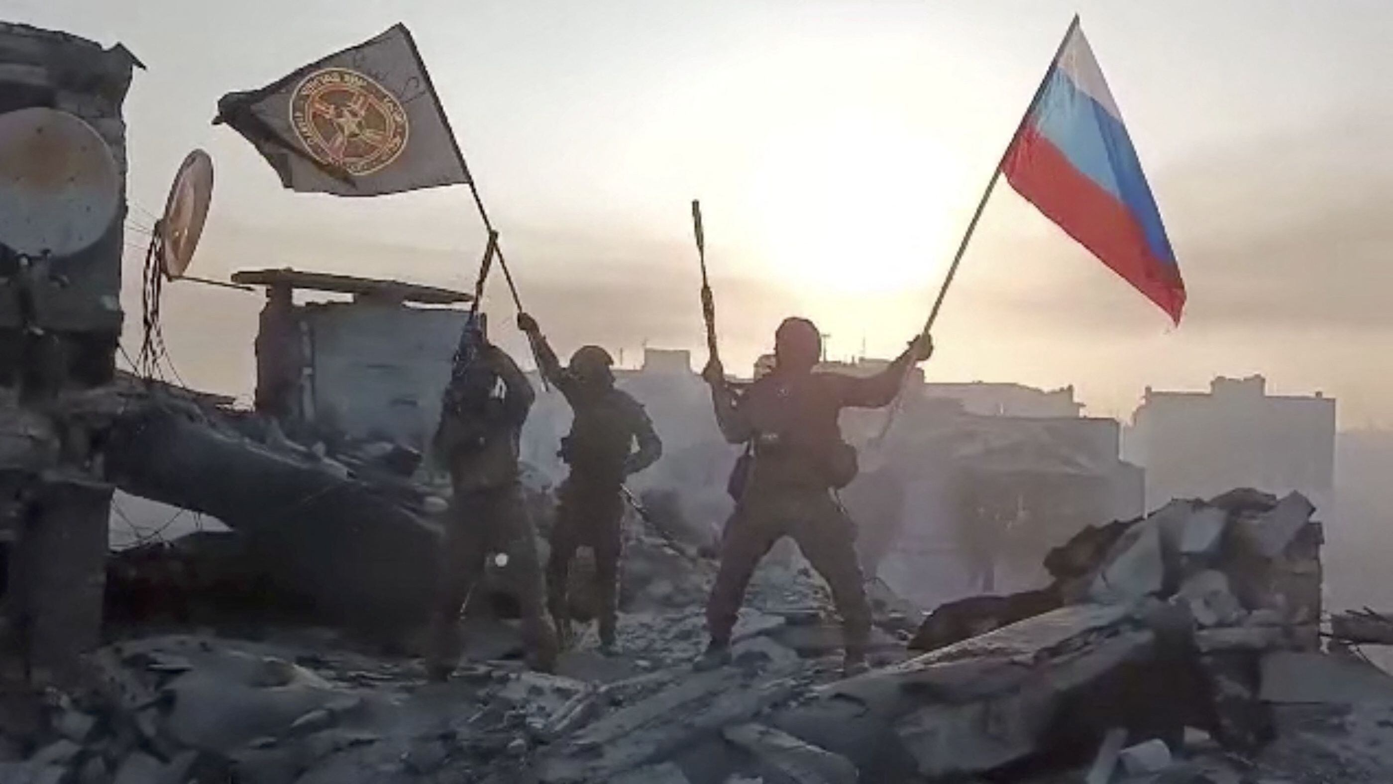 Wagner mercenary group fighters wave flags of Russia and Wagner group on the top of a building in an unidentified location in the course of Russia-Ukraine conflict, in this still image taken from video released on May 20, 2023, along with a statement by Russian mercenary chief Yevgeny Prigozhin about taking full control of the Ukrainian city of Bakhmut. Press service of "Concord"/Handout via REUTERS ATTENTION EDITORS - THIS IMAGE WAS PROVIDED BY A THIRD PARTY. NO RESALES. NO ARCHIVES. MANDATORY CREDIT.