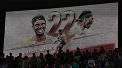 Spectators look on in front of a screen showing 22 Grand Slam titles for Spain's Rafael Nadal after his victory over Norway's Casper Ruud in their men's singles final match on day fifteen of the Roland-Garros Open tennis tournament at the Court Philippe-C