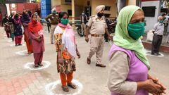 People maintain the recommended distance while waiting to receive free grocery items distributed by police officials during a government-imposed nationwide lockdown as a preventive measure against the COVID-19 novel coronavirus in Amritsar on March 30, 20
