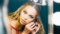 Beyoncé poniendose un pendiente frente al espejo