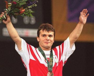 (FILES) This file photo taken on July 22, 1996 shows Naim Suleymanoglu of Turkey raising his arms at the medal ceremony where he was awarded the gold in the 64kg division Olympic weightlifing.