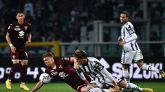 Torino's Dutch defender Perr Schuurs and Juventus' Serbian forward Dusan Vlahovic (R) fall as they collide during the Italian Serie A football match between Torino and Juventus on October 15, 2022 at the Olympic stadium in Turin. (Photo by Marco BERTORELLO / AFP)