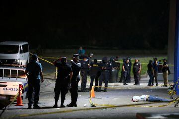 IMÁGENES SENSIBLES. Miembos de la policía salvadoreña crean un perímetro junto al cuerpo de una persona fallecida durante la avalancha en el Estadio Coscutlán.
