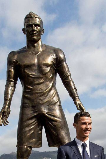 Cristiano Ronaldo poses beneath a statue of himself during the unveiling ceremony in his hometown of Funchal on December 21, 2014.