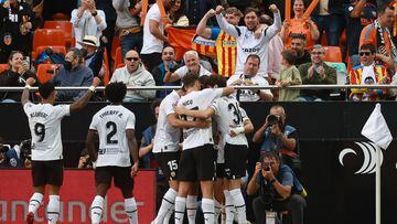Valencia's players celebrate the opening goal scored by Spanish forward Diego Lopez during the Spanish league football match between Valencia CF and Real Madrid CF at the Mestalla stadium in Valencia on May 21, 2023. (Photo by JOSE JORDAN / AFP)
