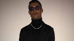 Cristiano Ronaldo vestido completamente de negro, con gafas de sol y con un collar plateado.