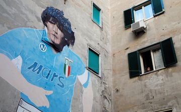 A mural depicting late soccer legend Diego Maradona is pictured, as people gather to mourn his death in Naples, Italy