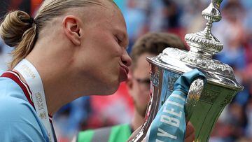 Manchester City's Norwegian striker Erling Haaland kisses the trophy after the English FA Cup final football match between Manchester City and Manchester United at Wembley stadium, in London, on June 3, 2023. (Photo by Adrian DENNIS / AFP) / NOT FOR MARKETING OR ADVERTISING USE / RESTRICTED TO EDITORIAL USE