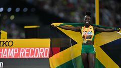 Gold medalist, Jamaica's Shericka Jackson celebrates with her National flag and medal beside a clock showing a new championship record after the women's 200m final during the World Athletics Championships at the National Athletics Centre in Budapest on August 25, 2023. (Photo by ANDREJ ISAKOVIC / AFP)