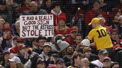 A fan holds up a sign mocking the Houston Astros sign-stealing cheating scandal during the first inning of game three of the MLB American League Championship Series between the Boston Red Sox and the Houston Astros at Fenway Park in Boston, Massachusetts,