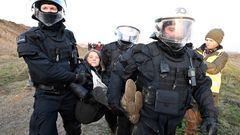17 January 2023, North Rhine-Westphalia, Erkelenz: Police officers carry Swedish climate activist Greta Thunberg (M) out of a group of protesters and activists and away from the edge of the Garzweiler II opencast lignite mine. Activists and coal opponents continue their protests at several locations in North Rhine-Westphalia on Tuesday. Photo: Roberto Pfeil/dpa (Photo by Roberto Pfeil/picture alliance via Getty Images)