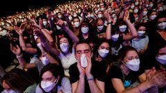 People wearing protective masks attend a concert of &quot;Love of Lesbian&quot; at the Palau Sant Jordi, the first massive concert since the beginning of the coronavirus disease (COVID-19) pandemic in Barcelona, Spain, March 27, 2021. REUTERS/Albert Gea