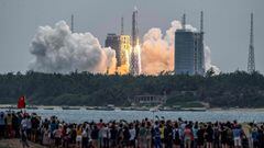 TOPSHOT - People watch a Long March 5B rocket, carrying China&#039;s Tianhe space station core module, as it lifts off from the Wenchang Space Launch Center in southern China&#039;s Hainan province on April 29, 2021. (Photo by STR / AFP) / China OUT