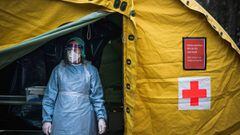 A medical staffer at Sophiahemmet hospital stands at the entrance of a tent for testing and receiving potential coronavirus COVID-19 patients on April 7, 2020 in Stockholm. (Photo by Jonathan NACKSTRAND / AFP)