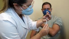 A nurse prepares to inoculate Physician Rafael Carraro,