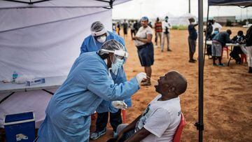 A man, a resident of the sprawling township of Alexandra in Johannesburg, opens his mouth to receive a testing swab for COVID-19 coronavirus at a screening and testing drive in front of the Madala Hostel, on April 27, 2020. (Photo by MARCO LONGARI / AFP)
