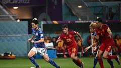 Japan's midfielder #15 Daichi Kamada (L) is chased by Spain's midfielder #26 Pedri (C) during the Qatar 2022 World Cup Group E football match between Japan and Spain at the Khalifa International Stadium in Doha on December 1, 2022. (Photo by Anne-Christine POUJOULAT / AFP)