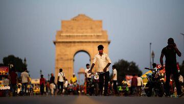 A vendor (C) wearing a facemask as a preventive measure against the Covid-19 coronavirus looks for customers to ride his toy bike along the Rajpath street near India Gate in New Delhi on September 16, 2020. - Coronavirus infections in India soared past fi
