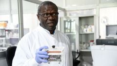 (FILES) In this file photo taken on June 02, 2020 Professor Christian Happi, the director of African Centre of Excellence for Genomics of Infectious Diseases (ACEGID), holds a minipcr thermal cycler, a laboratory apparatus used to amplify segments of DNA 