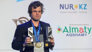 Magnus Carlsen sostiene el trofeo de campeón mundial de ajedrez rápido 2022.