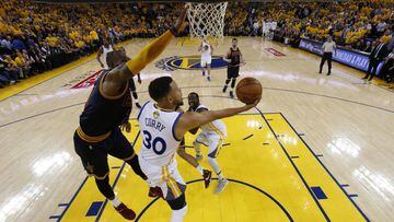 MON130. OAKLAND (EE.UU.), 01/06/2017.- Stephen Curry (c) de Golden State Warriors disputa el bal&oacute;n con LeBron James (i) de Cleveland Cavaliers hoy, jueves 1 de junio de 2017, durante el primer juego de la final de la NBA entre Cleveland Cavaliers y Golden State Warriors, que se disputa en el Oracle Arena, en Oakland, California (Estados Unidos). EFE/MARCIO JOSE SANCHEZ / POOL