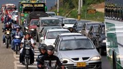 Carros y motos atrapados en un trancón en una vía de Medellín, Antioquia.