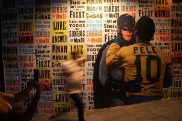 Una persona pasa frente a un graffiti que representa a Pelé abrazando a Batman en Sao Paulo, Brasil, el 29 de diciembre de 2022