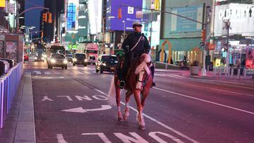 A mounted police officer rides though a mostly deserted Times Square. 