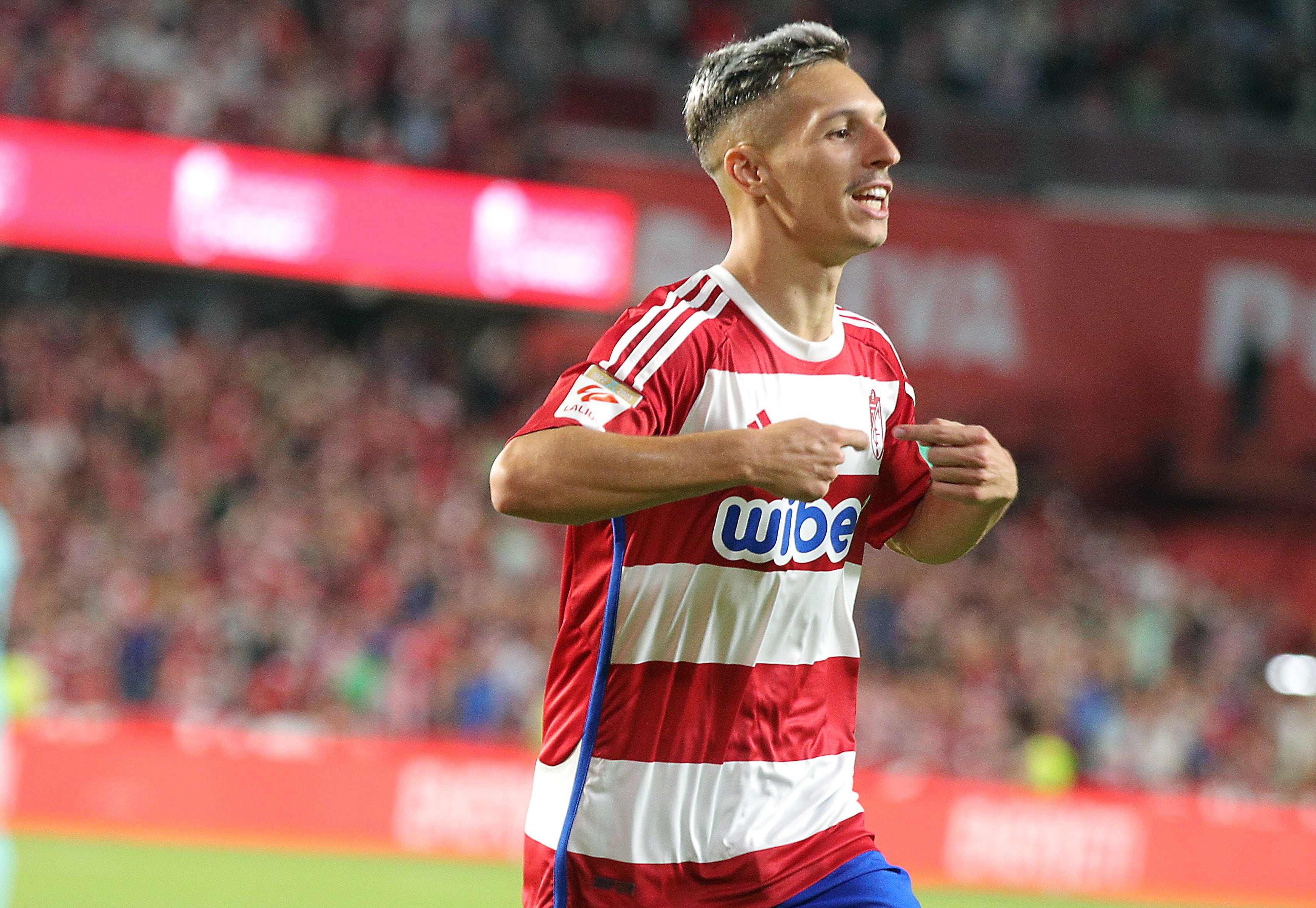 GRANADA, 08/10/2023.- El delantero del Granada, Bryan Zaragoza, celebra el segundo gol de su equipo durante el encuentro correspondiente a la jornada nueve de primera división que disputan hoy Domingo frente al FC Barcelona en el estadio Nuevo Los Cármenes, en Granada. EFE / Pepe Torres.
