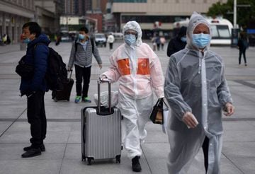 Passengers wearing face masks arrive at the Hankou railway station in Wuhan on April 11.