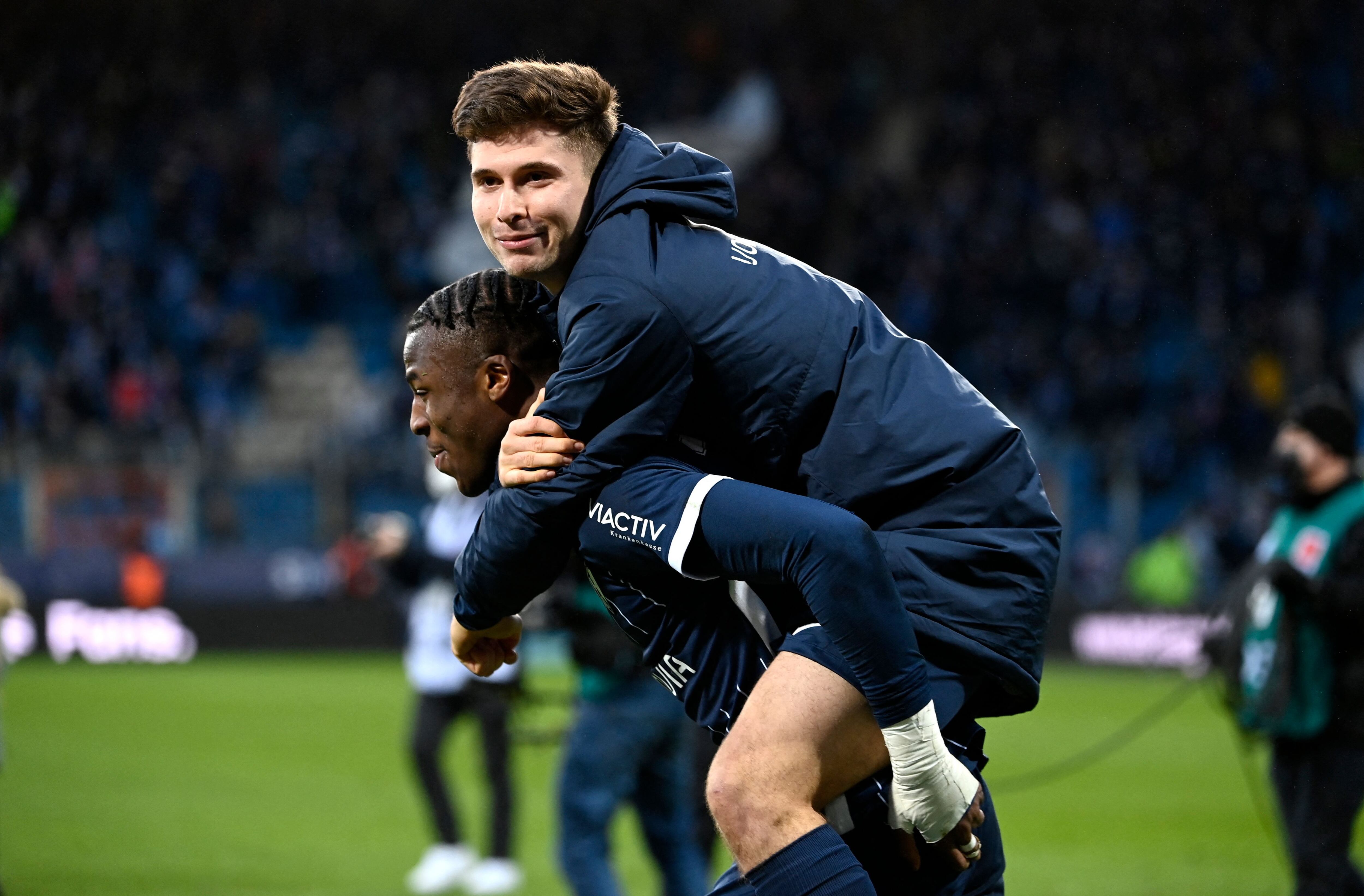 Bochum's German defender Armel Bella Kotchap and Bochum's German-Kosovan midfielder Elvis Rexhbecaj (R) celebrate victory after the German first division Bundesliga football match between VfL Bochum and FC Bayern Munich in Bochum, western Germany on February 12, 2022. (Photo by Ina FASSBENDER / AFP) / DFL REGULATIONS PROHIBIT ANY USE OF PHOTOGRAPHS AS IMAGE SEQUENCES AND/OR QUASI-VIDEO