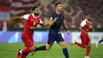 Nassr's Portuguese forward #07 Cristiano Ronaldo and Persepolis #06 Hossein Kanani vie for the ball during the AFC Champions League group E football match between Persepolis FC and al-Nassr FC at Tehran's Azadi stadium, on September 19, 2023. (Photo by ATTA KENARE / AFP)