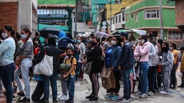 Familias hacen fila en una calle de Bogotá, Colombia