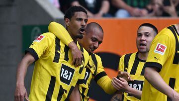 Dortmund's French forward Sebastien Haller (L) celebrates scoring the opening goal with his teammate Dortmund's Dutch forward Donyell Malen (C) and Dortmund's Portuguese defender Raphael Guerreiro during the German first division Bundesliga football match between FC Augsburg and BVB Borussia Dortmund in Augsburg, southern Germany, on May 21, 2023. (Photo by Christof STACHE / AFP) / DFL REGULATIONS PROHIBIT ANY USE OF PHOTOGRAPHS AS IMAGE SEQUENCES AND/OR QUASI-VIDEO
